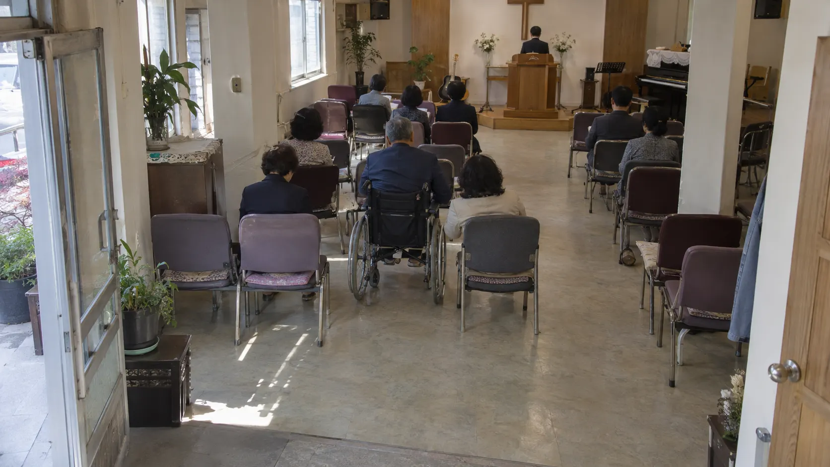 휠체어 이용자가 동행인과 나란히 앉을 자리와 좌석까지 이어지는 통로를 함께 살피는 예배 공간입니다. 출입문을 지나 자리에 앉는 과정에서 통로의 물건이나 좌석 배치가 이동을 가로막는지도 점검합니다.