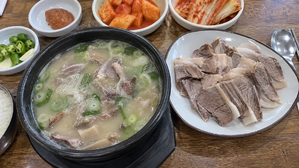 국밥 1그릇에 들어 있는 고기와 별도 접시에 담긴 고기를 나란히 보여 줍니다. 국 안의 건더기와 정식에 추가되는 고기 접시를 구분하는 예시 장면입니다. 실제 구성과 제공량은 메뉴 설명을 기준으로 읽습니다.