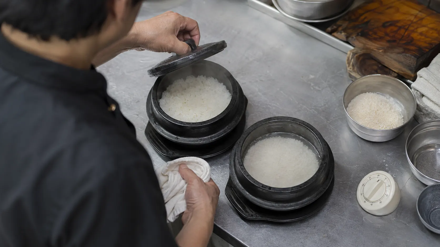 주문량에 맞춰 1인분 솥을 나누어 조리하고 밥의 익는 상태와 제공 순서를 확인하는 주방 작업 장면입니다. 미리 지은 밥의 보온 용량을 따로 관리하는 모습도 함께 담았습니다.