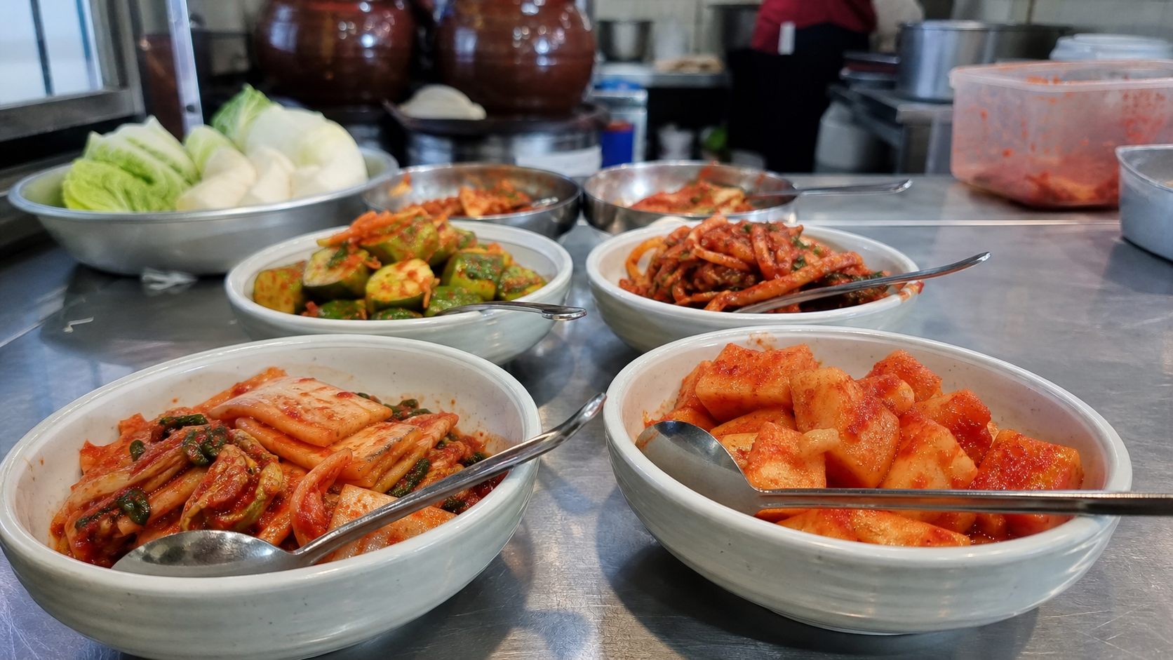 김장김치의 매운맛, 숙성도, 양념 배합을 비교하기 위해 여러 시료를 나란히 놓고 확인하는 장면 — 맛의 균일성과 맞춤 레시피(김장김치 가격 전문) 내용을 보여주는 사진