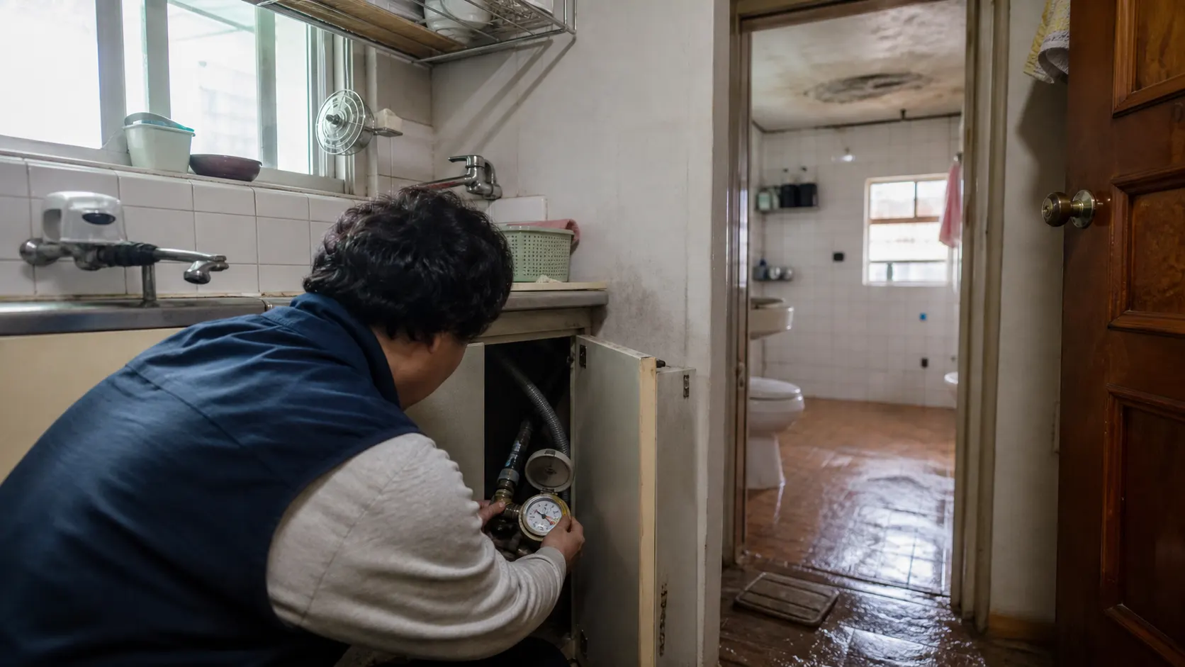 물을 사용하지 않는 주방에서 계량기 별침을 확인하고 욕실 바닥, 아랫집 천장, 외벽 주변의 물자국을 발생 조건별로 기록해 배관과 결로를 구분하는 점검 장면입니다.