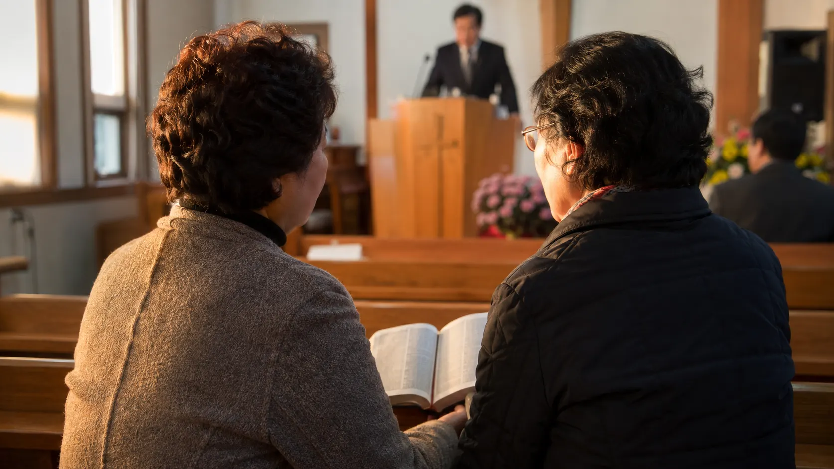 인도자와 회중이 열린 성경을 앞에 두고 자신의 차례를 기다리며 말씀을 번갈아 읽는 예배 장면입니다. 주보의 역할 구분에 따라 함께 소리 내는 흐름이 드러납니다.