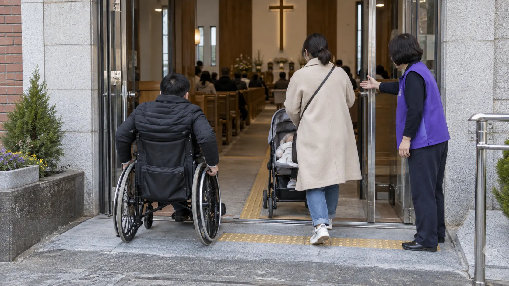 휠체어 이용자와 유모차를 미는 보호자가 턱 없는 출입구로 들어가고, 안내자가 바닥의 촉각 유도선과 막힘 없는 통로를 가리키며 예배실까지 이어지는 이동 흐름을 보여 주는 장면입니다.
